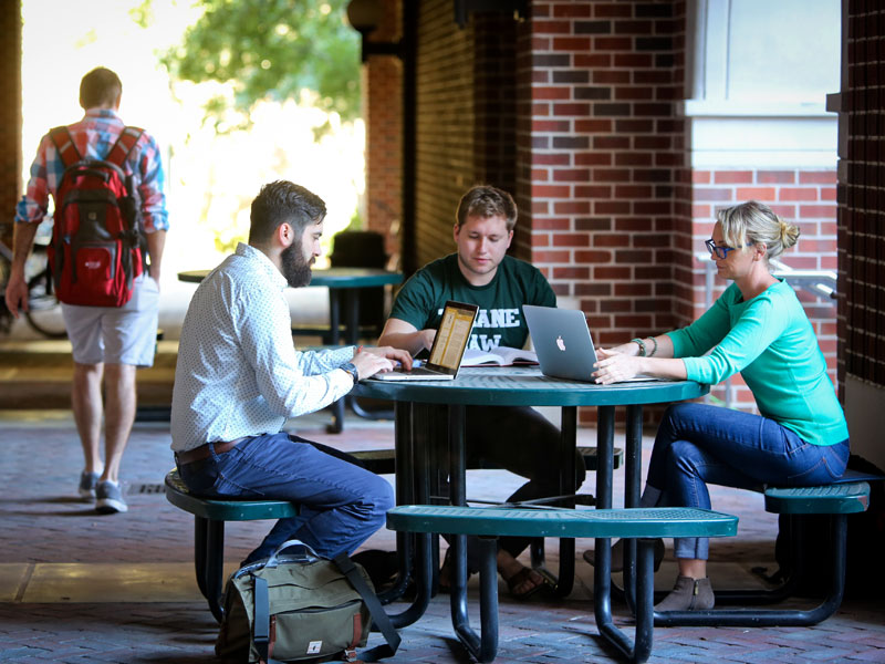 Students working together in the Weinmann Hall courtyard